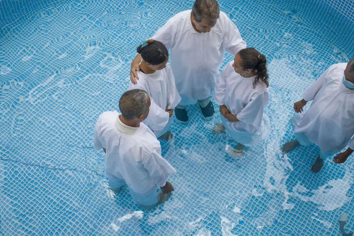 Aerial view of a group of people in white robes standing in a baptism pool