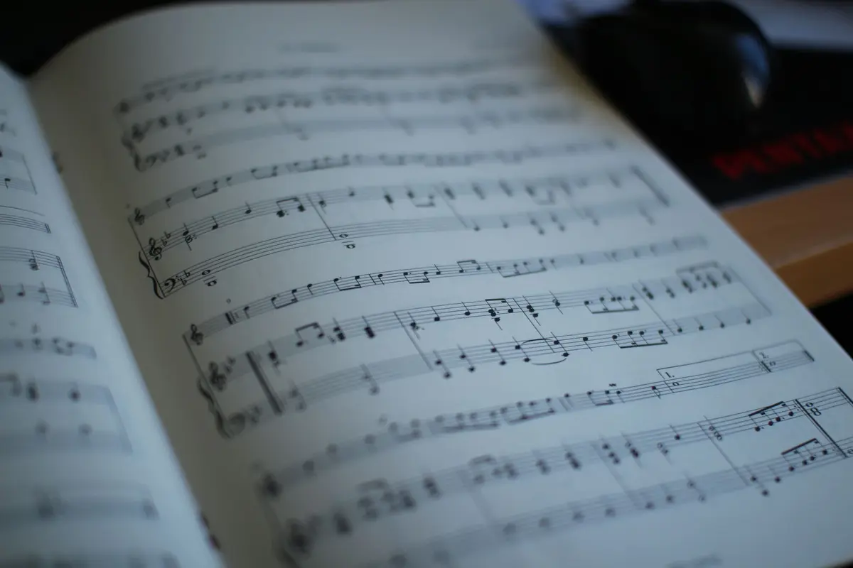 Close-up of an open music book showing printed sheet music notes