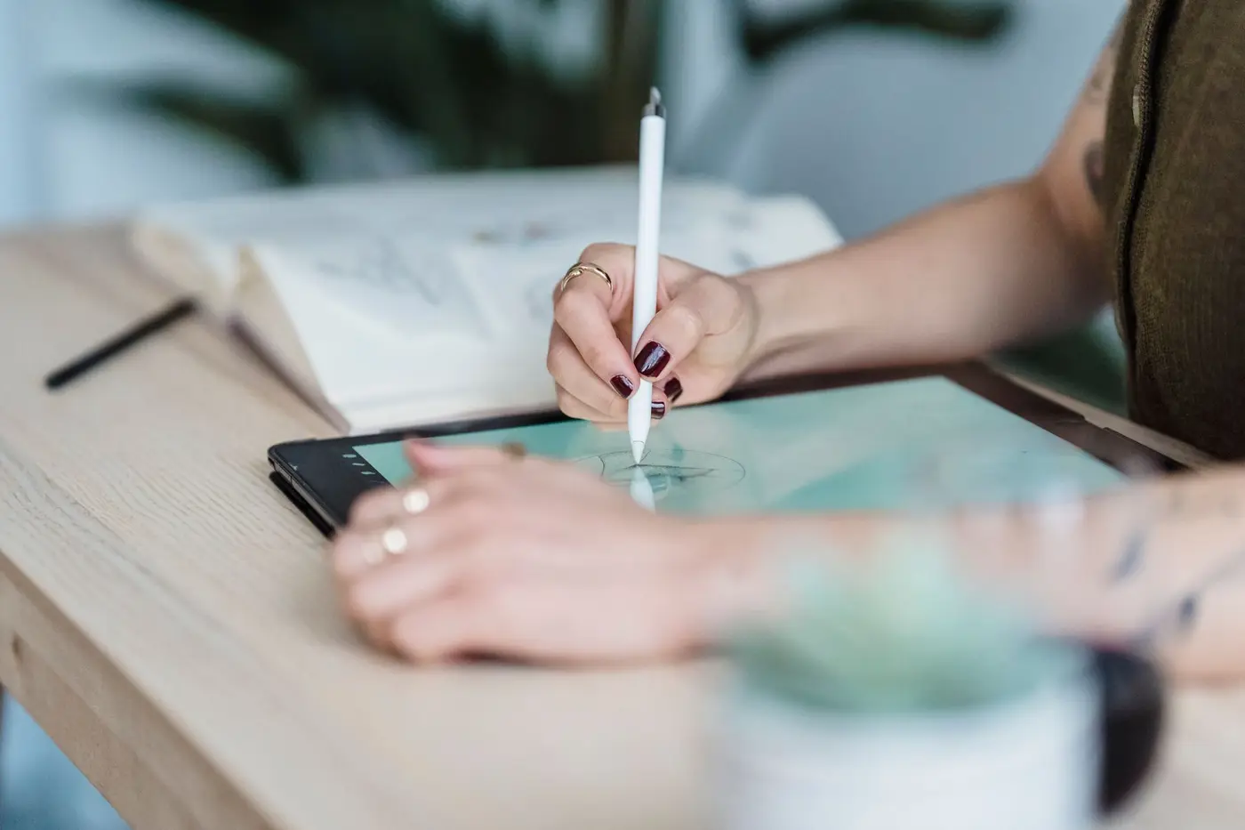 A designer sketching a t-shirt design on a tablet