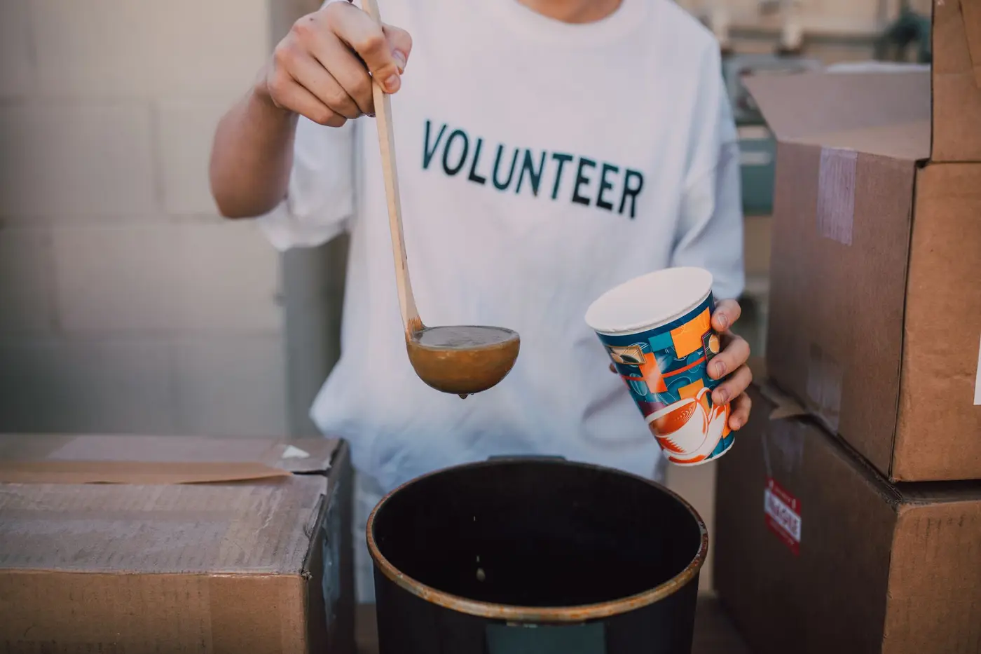 A volunteer wearing a printed t-shirt serving food at a community event