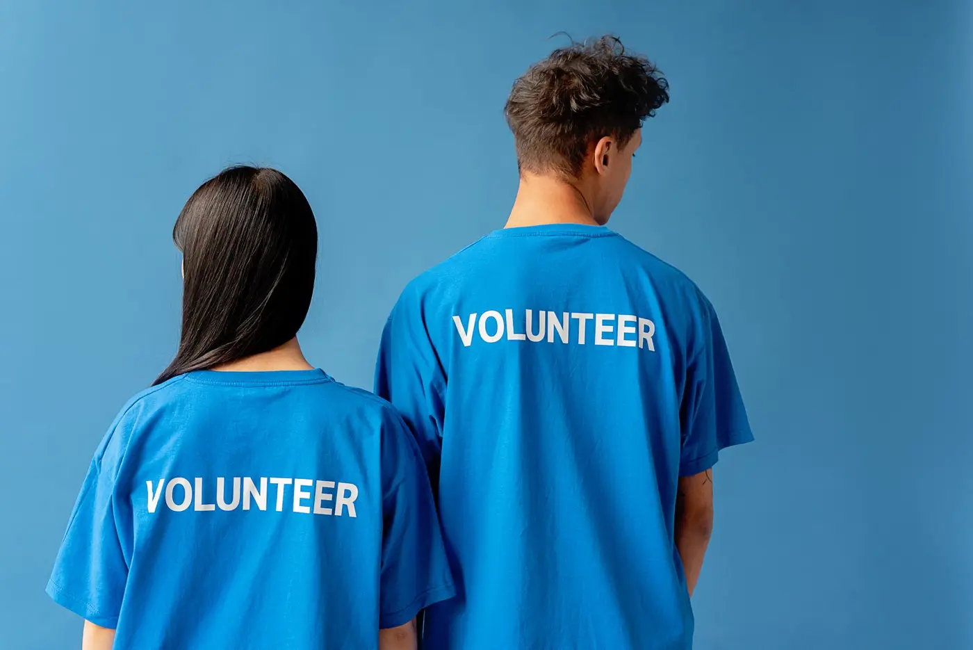 Two volunteers wearing blue printed volunteer t-shirts