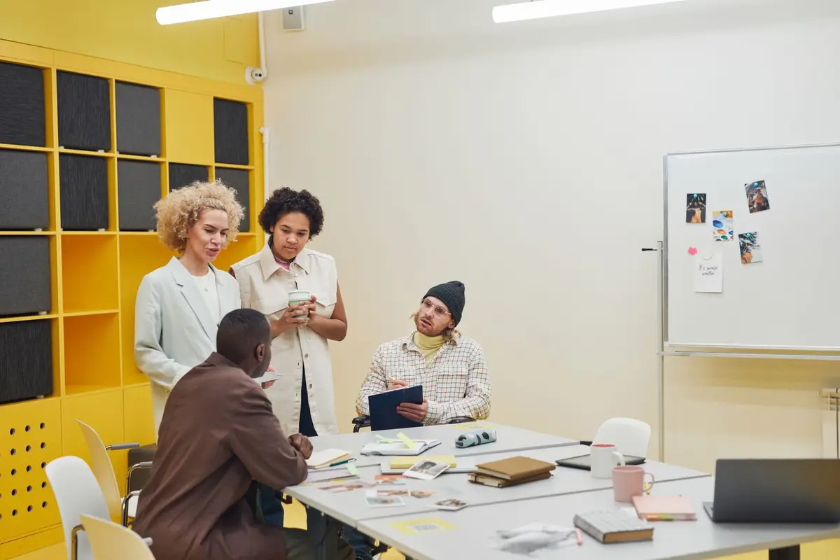 A group of professionals talking together around a table in a modern office