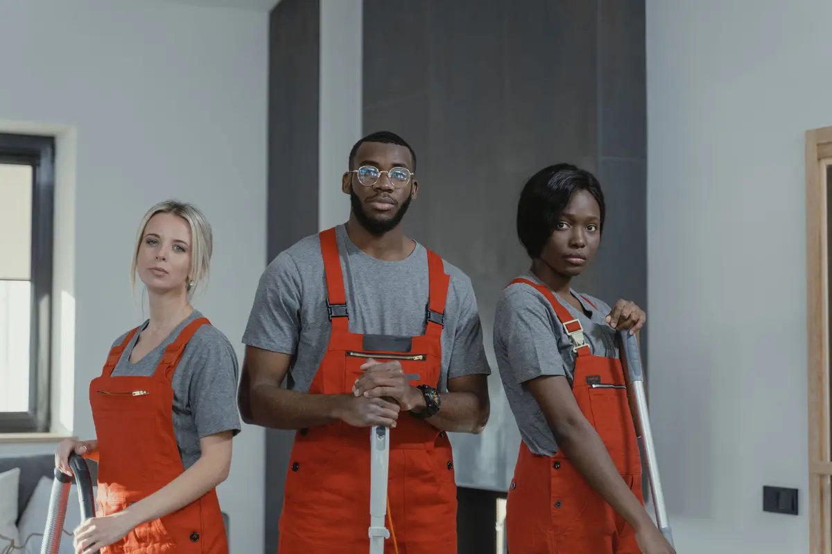 A cleaning team in matching branded shirts and aprons ready for a job