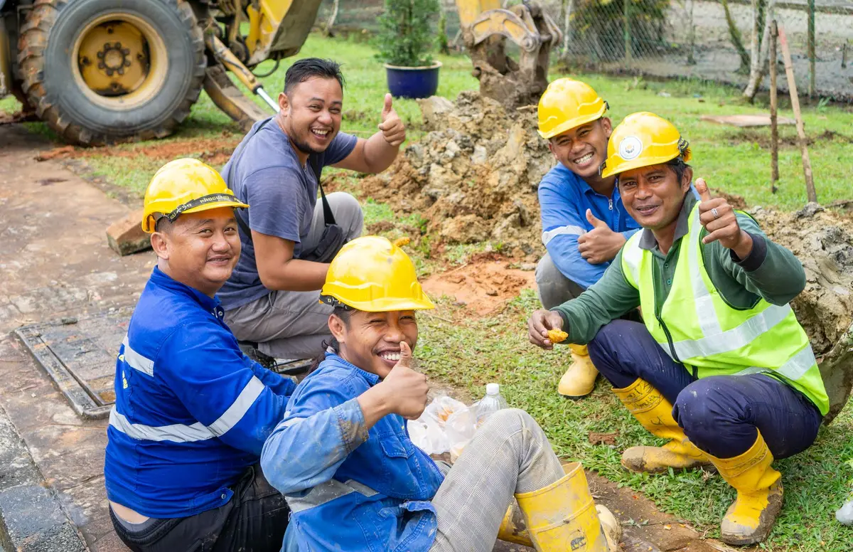 A construction crew in hard hats and hi-vis gear taking a break together on site