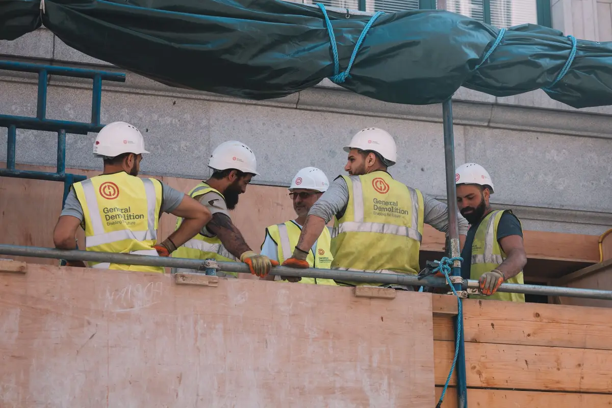 A construction crew in matching branded hi-vis vests working at a city job site