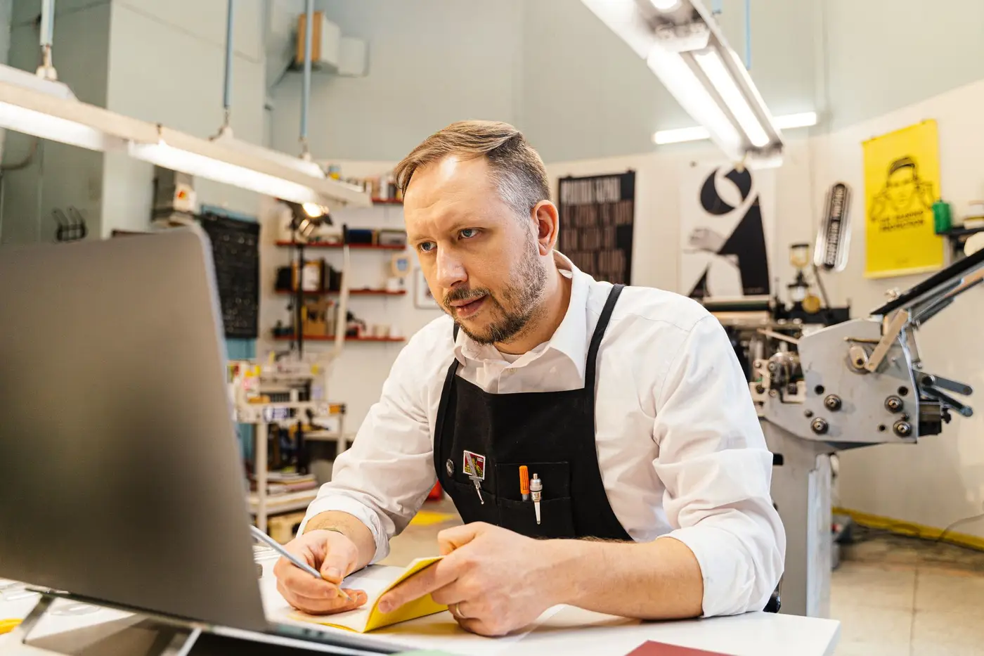 A print shop worker planning a job at a computer
