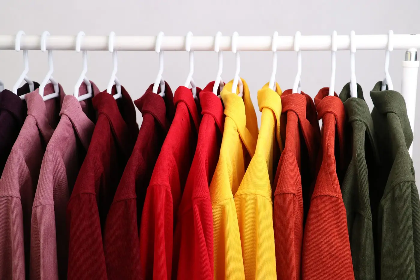 A rack of blank t-shirts arranged by color