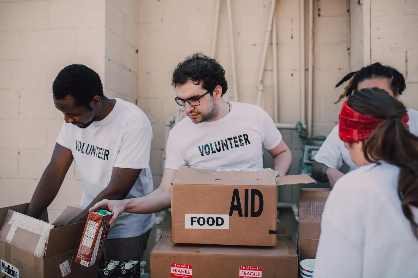 Volunteers in printed shirts packing boxes at a community aid drive