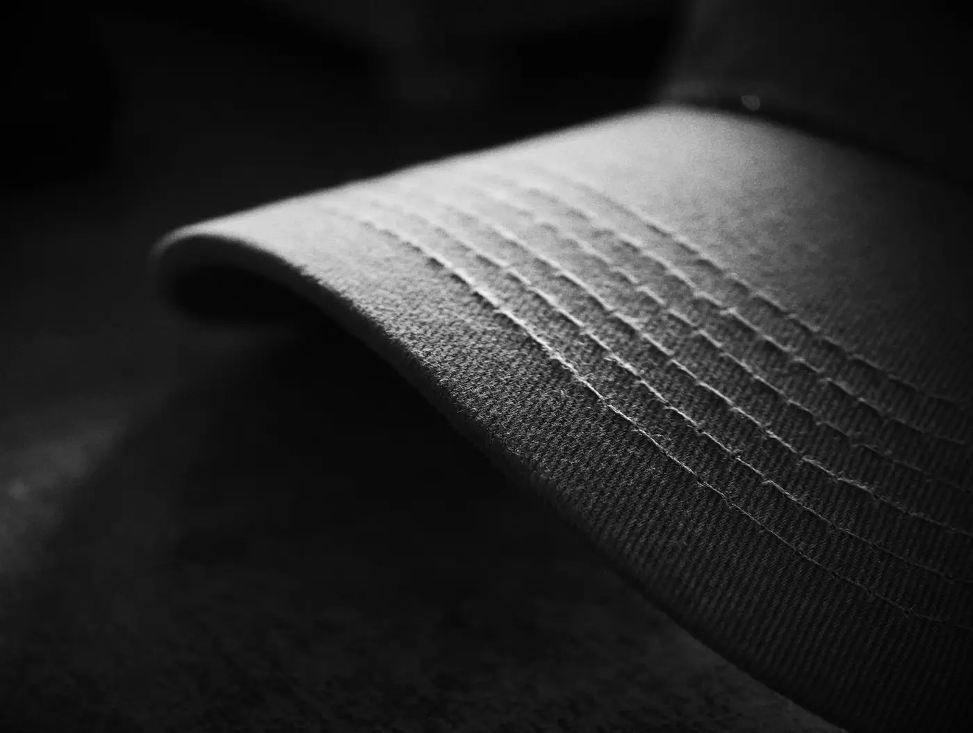Close-up of a baseball cap showing the curved crown and stitching