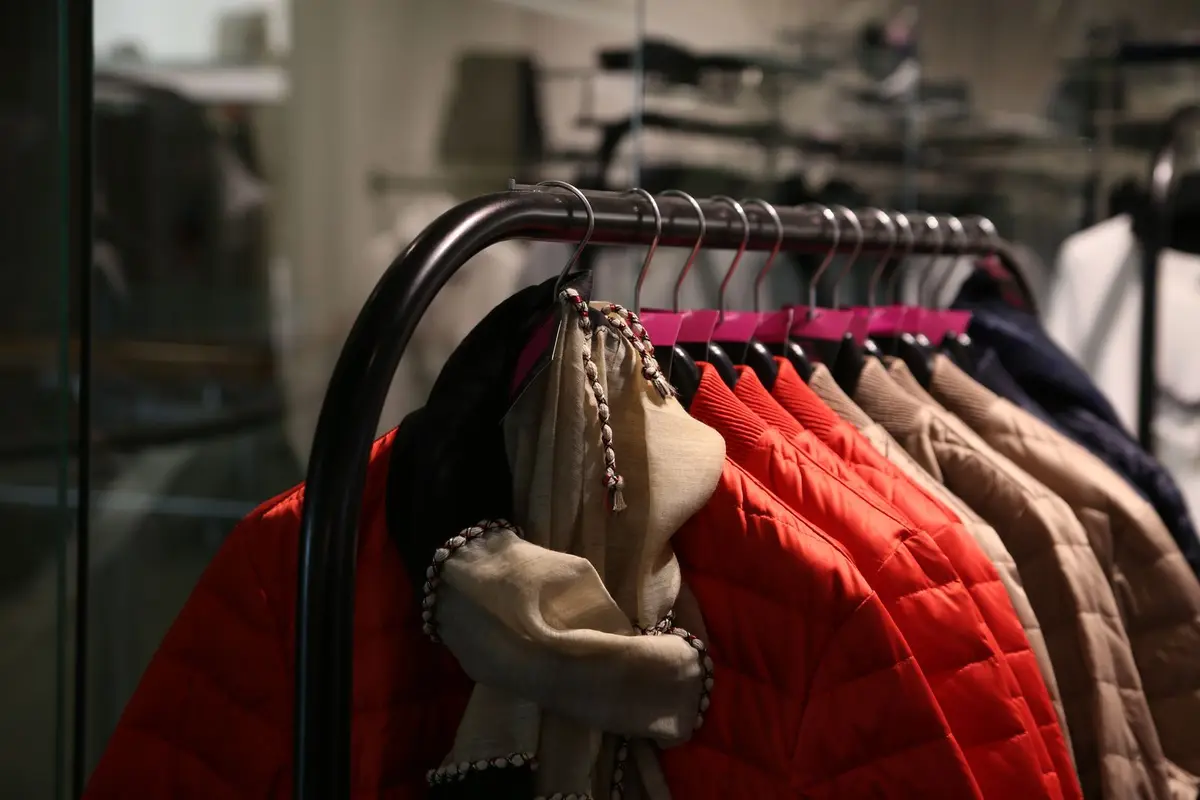 Jackets and coats in various colors hanging on a clothing rack