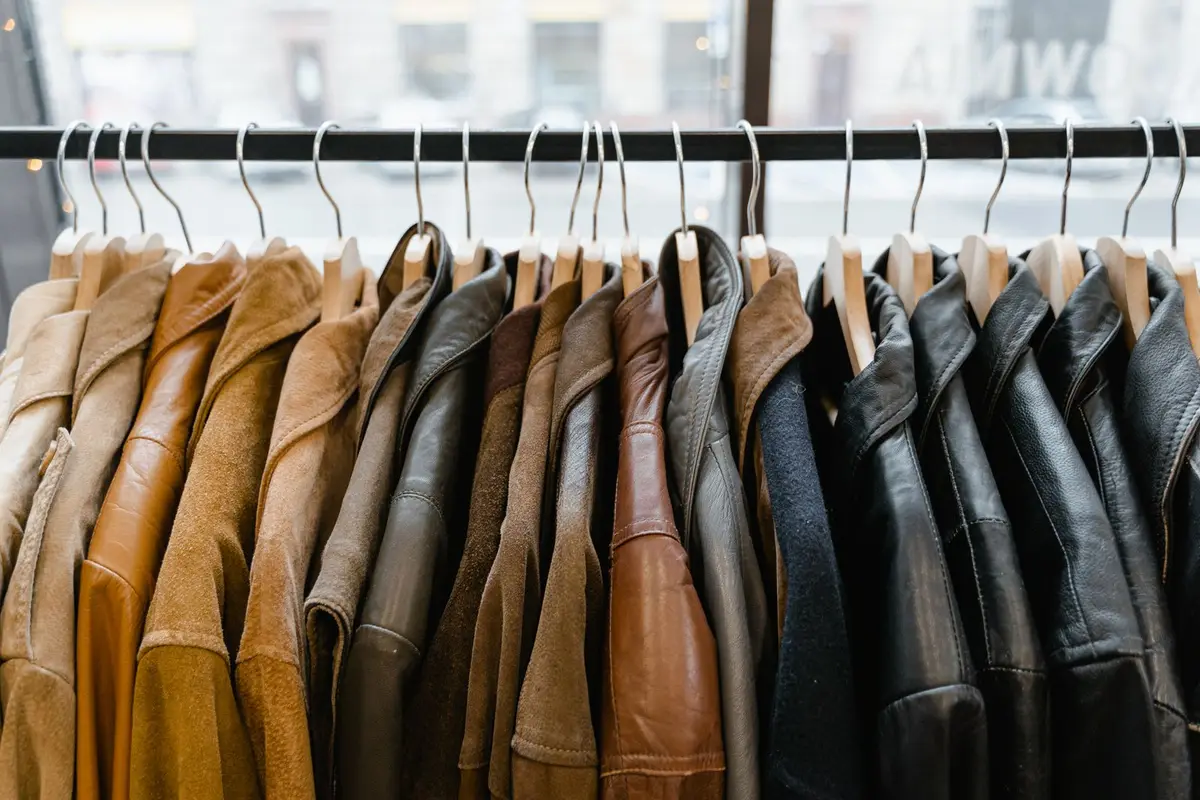 A row of premium leather and suede jackets hanging on a rack in a boutique