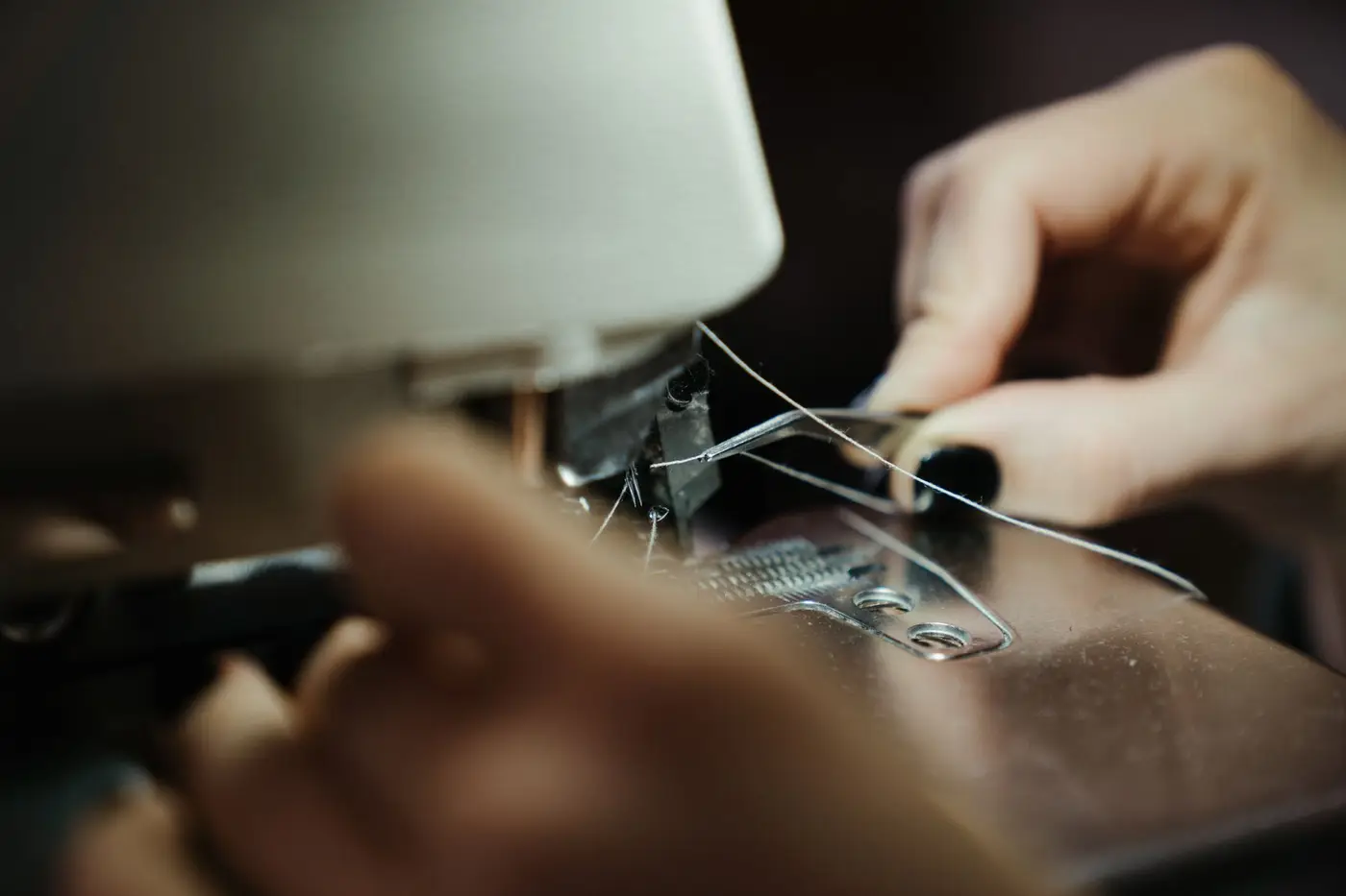 Hands guiding fabric through a sewing machine