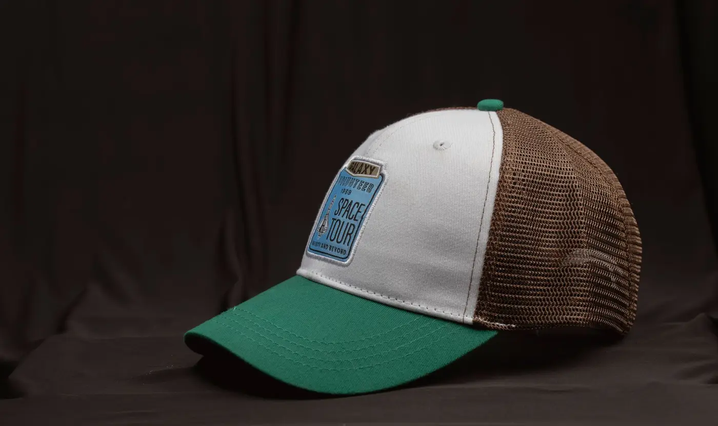 A trucker cap with a woven patch sewn onto the front panel