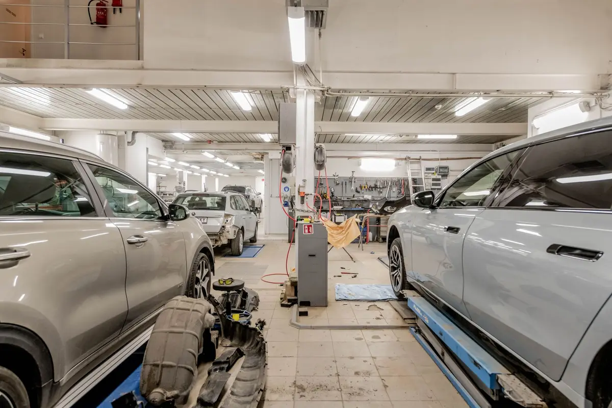 The interior of an automotive repair shop with cars up on lifts