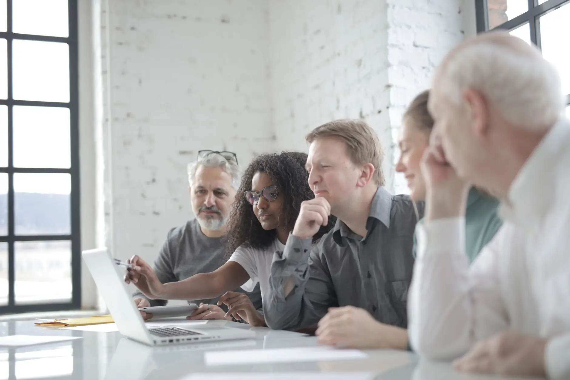 A team reviewing plans together around a laptop