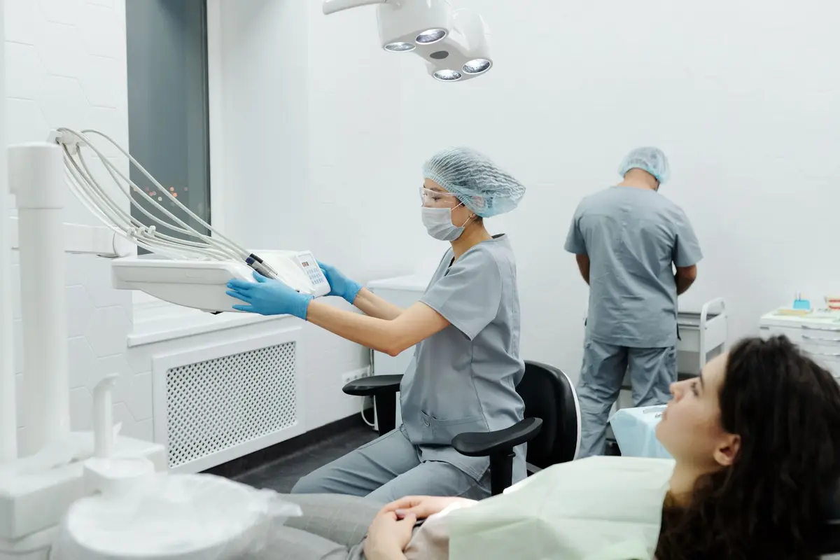 A dental team in matching scrubs treating a patient in a modern clinic