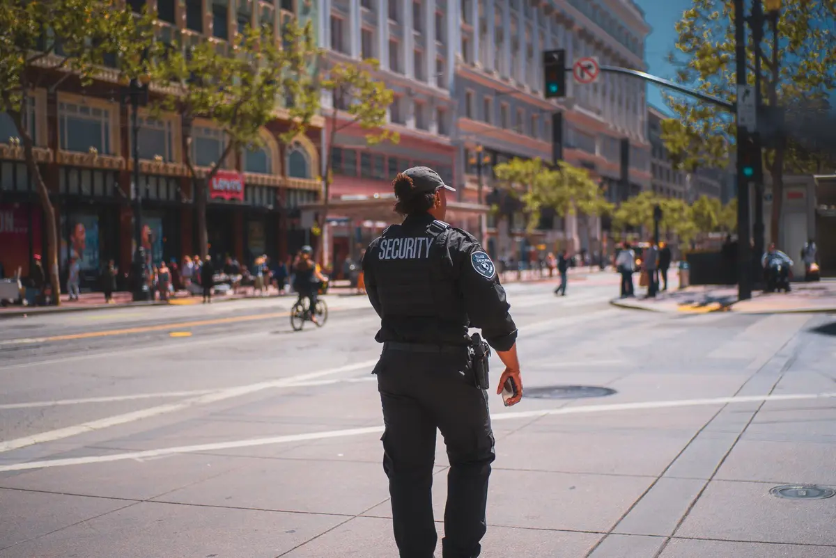 A security officer seen from behind with SECURITY printed across the back of the uniform