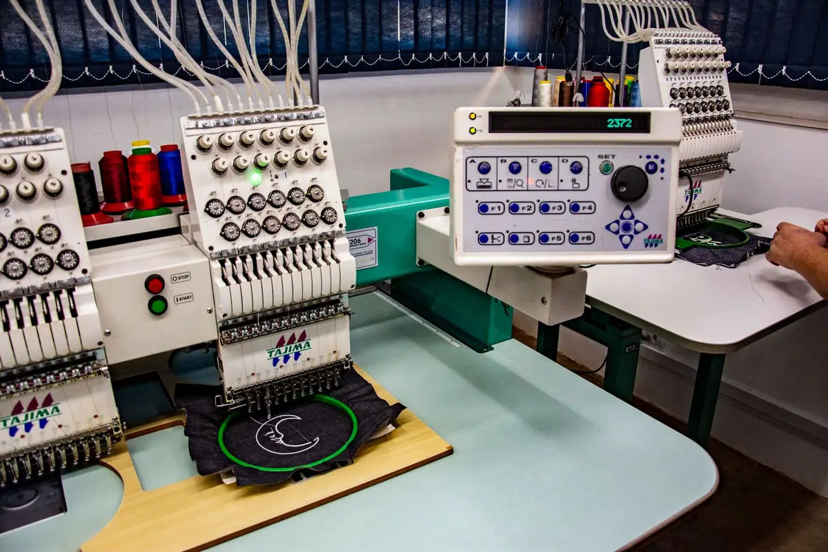 Commercial embroidery machines stitching logos in a workshop