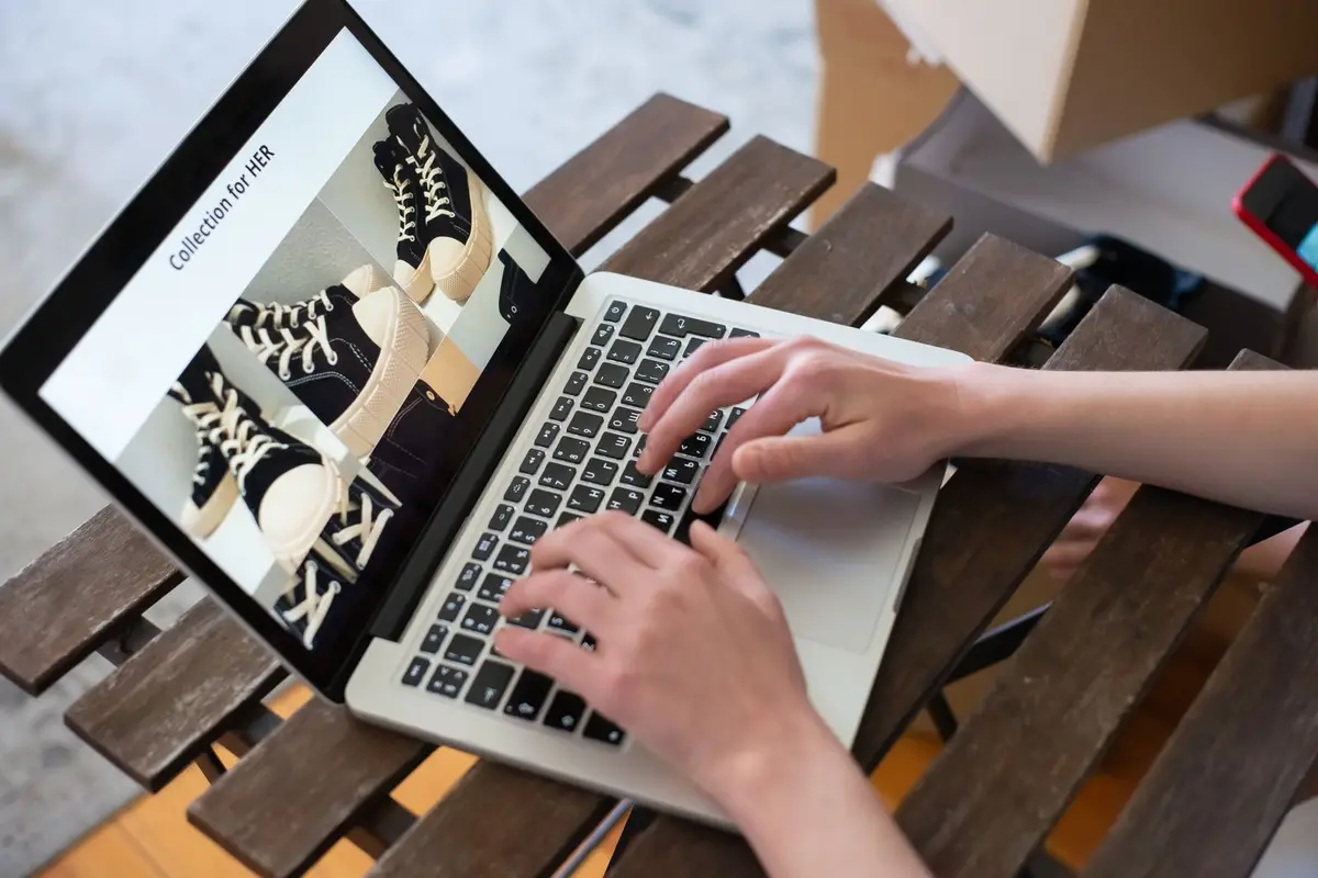 Hands browsing an online store collection on a laptop