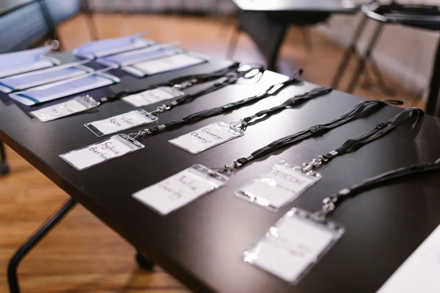 Name badges and lanyards laid out on a table at a conference
