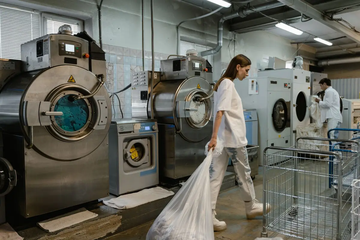 Workers handling garments in a busy industrial laundry facility