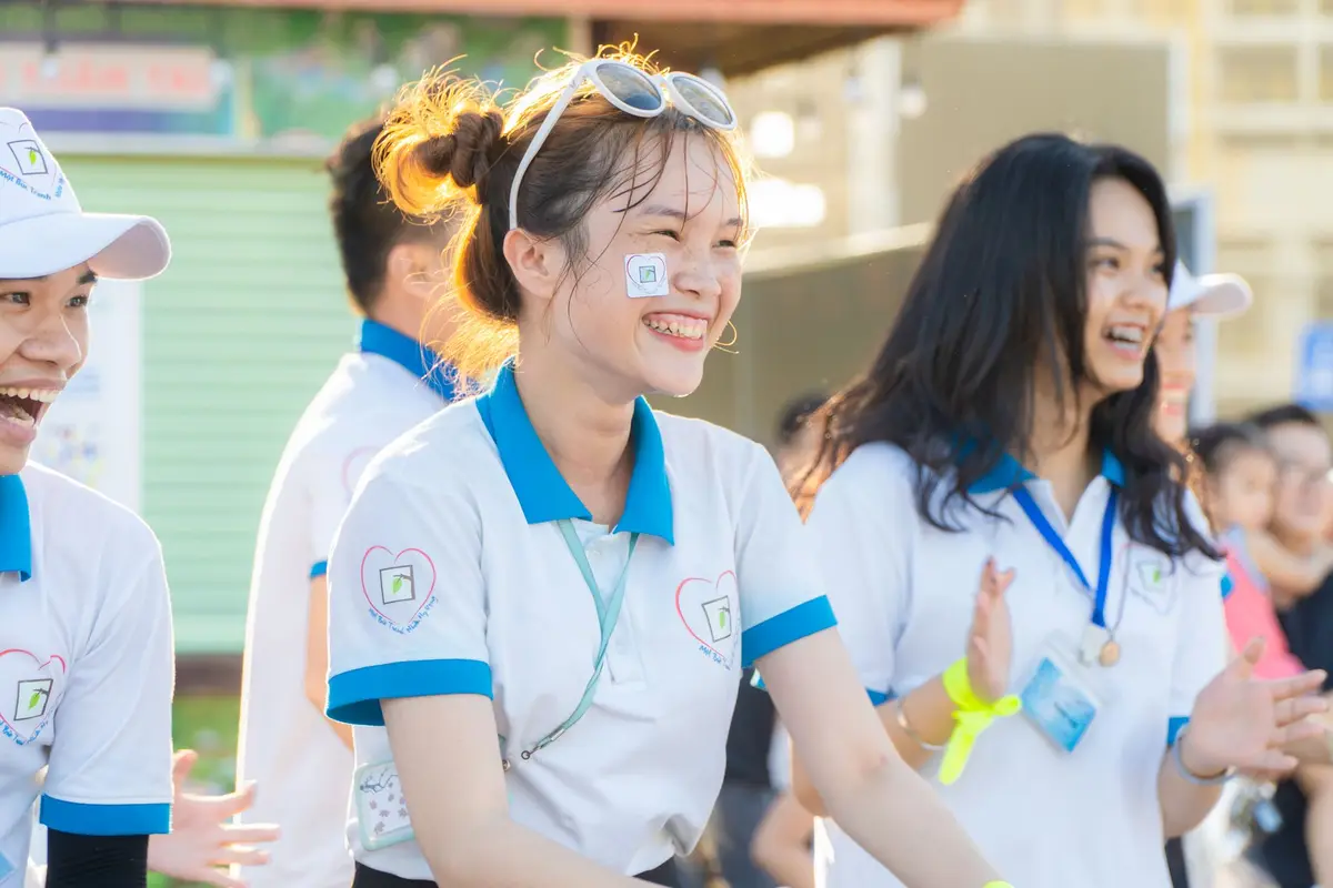 A group of smiling volunteers in matching shirts at an outdoor event