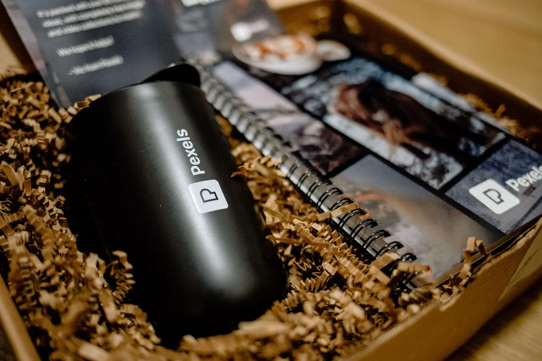 A branded mug and notebook packed in a kraft-paper gift box