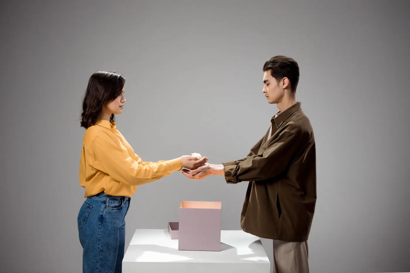 Two people exchanging a gift box