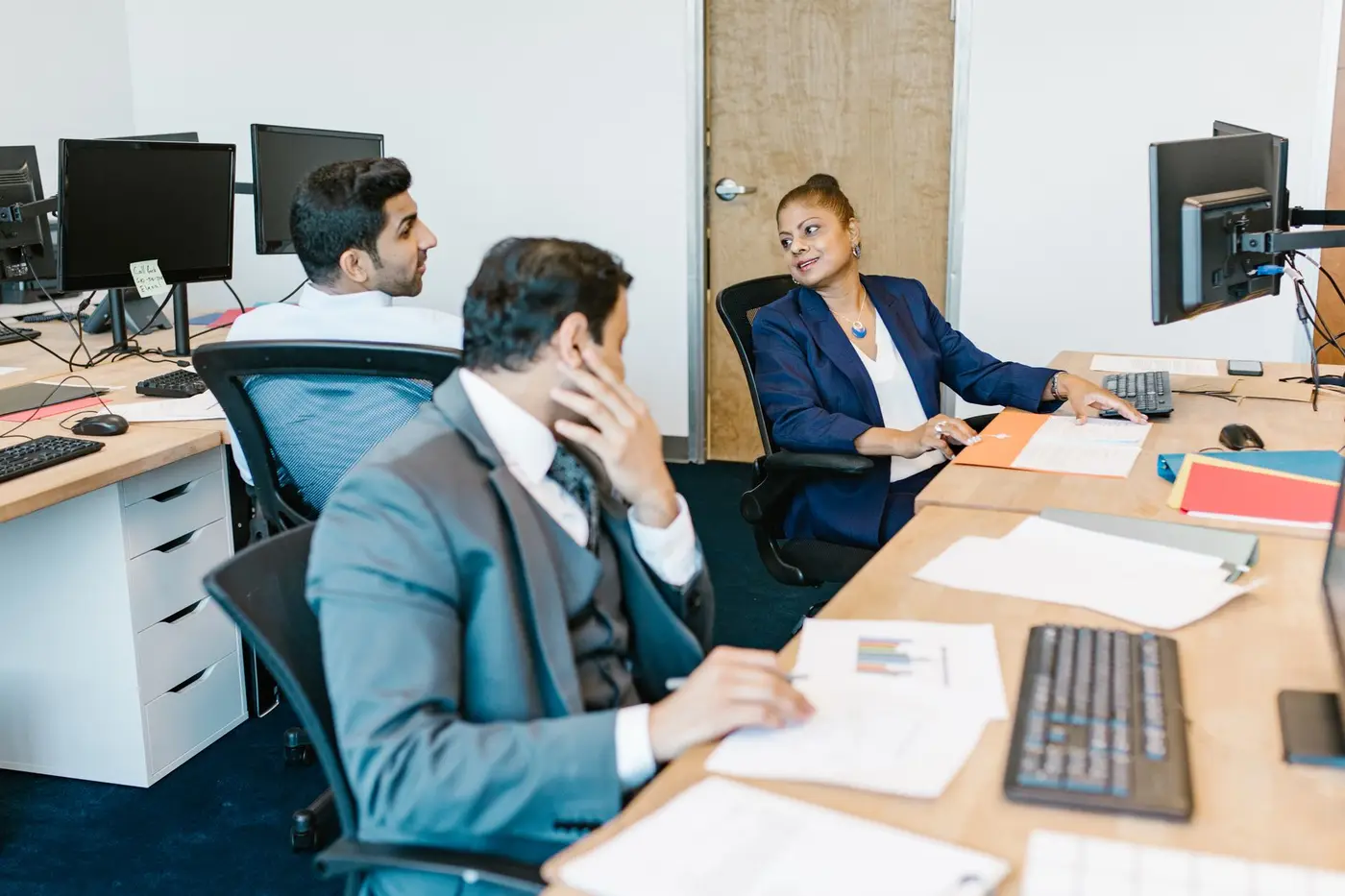 Colleagues working together at desks in an open office