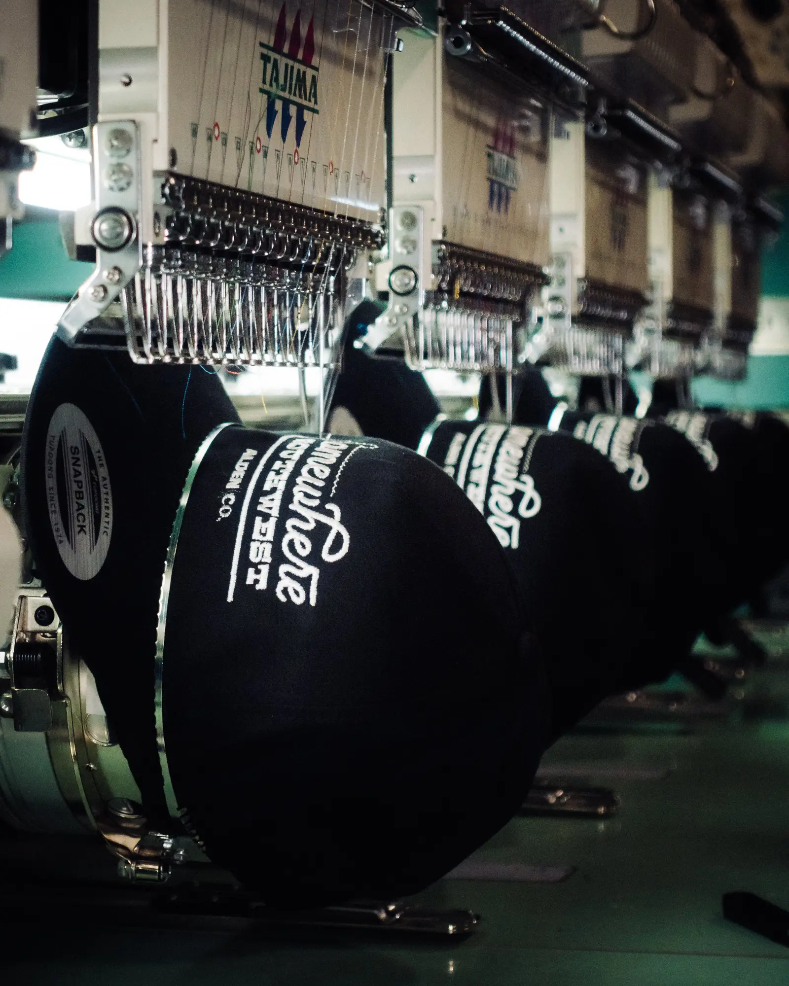 Multiple caps being embroidered at once on a commercial multi-head machine