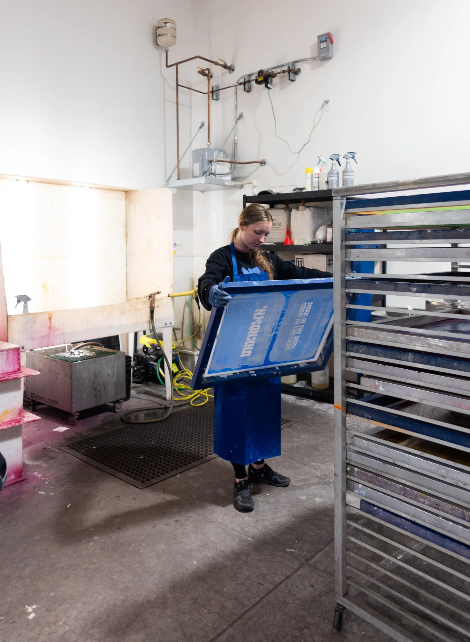 A team member reclaiming a screen at the washout booth